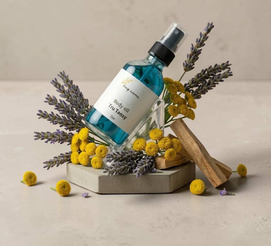 Body oil bottle with lavender and yellow flowers on a neutral background